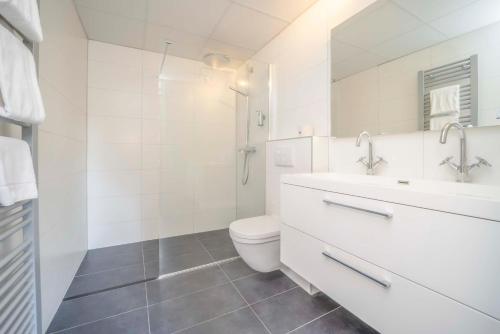 a white bathroom with a toilet and a sink at Fletcher Hotel-Restaurant Waalwijk in Waalwijk