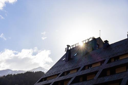 a building with the sun shining on the roof at RVHotels Tuca in Vielha