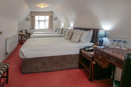 a large bedroom with a large bed and a desk at Weston Hall Hotel Sure Hotel Collection by Best Western in Bulkington