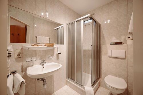 a bathroom with a shower and a sink and a toilet at Hotel Lisa in Flachau