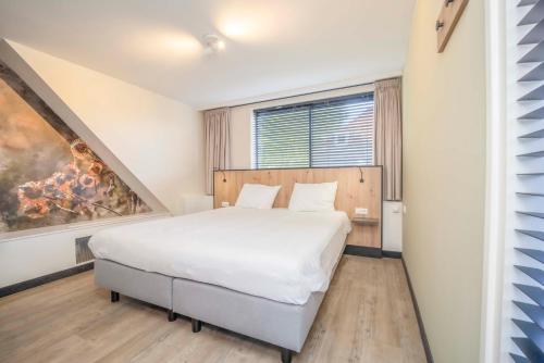 a bedroom with a white bed and a large window at Fletcher Hotel-Restaurant Waalwijk in Waalwijk