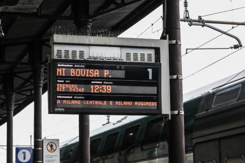 a sign at a train station with a train at SUITE ANGOLO ALLA STAZIONE - Appartamento con terrazzo panoramico in Pavia