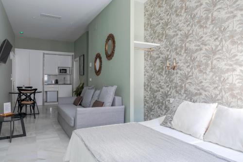 a bedroom with a bed and a living room with a couch at Luces de Catedral in Alicante