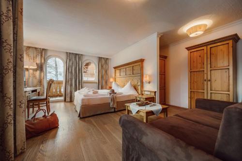 ein Hotelzimmer mit 2 Betten und einem Sofa in der Unterkunft Hotel Lisa in Flachau