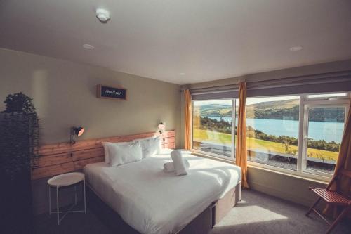 ein Schlafzimmer mit einem großen Bett und einem großen Fenster in der Unterkunft Boreland Loch Tay in Aberfeldy
