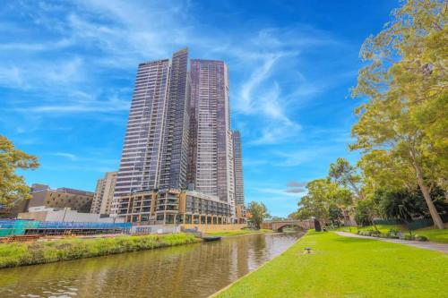 un grand bâtiment dans une ville à côté d'une rivière dans l'établissement 2Bedrooms 2Bathrooms Oasis in Parramatta w parking, à Sydney