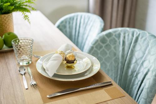 a table with a plate with a gold egg on it at SCHLOSSRESIDENZ - Boutique Apartments & Hotel Suiten in Schloß Ricklingen