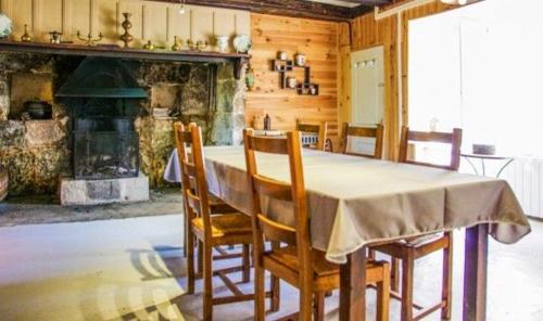 une salle à manger avec une table et des chaises et une cheminée dans l'établissement Ancienne maison de ferme avec vue montagne à Cheylade, à Cheylade
