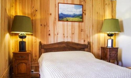 une chambre avec un lit et deux lampes dedans dans l'établissement Ancienne maison de ferme avec vue montagne à Cheylade, à Cheylade