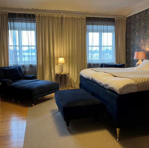 a hotel room with a bed and a chair and windows at Best Western Motala Stadshotell in Motala