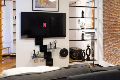 un soggiorno con TV a schermo piatto a parete di Farris & Cors Casa Sansiro a Genova