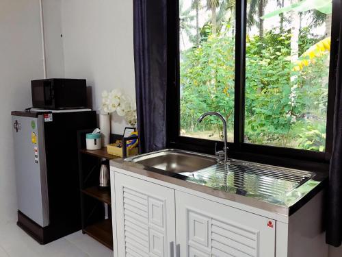 uma cozinha com um lavatório e uma janela em Minds House 