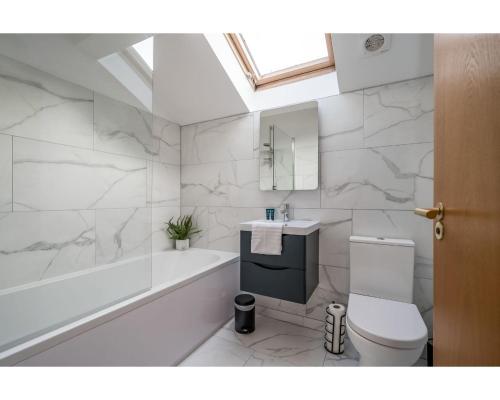 uma casa de banho com um WC, uma banheira e um lavatório. em Central Belfast Apartments Pottinger's Quay em Belfast