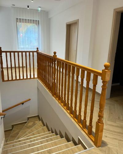 a staircase in a house with wooden railings at Casa Forrest & SPA in Muntele Săcelului