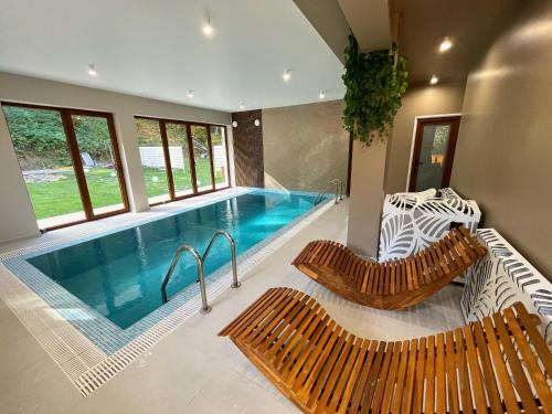 una piscina con 2 bancos y una piscina en Casa Forrest & SPA, en Muntele Săcelului