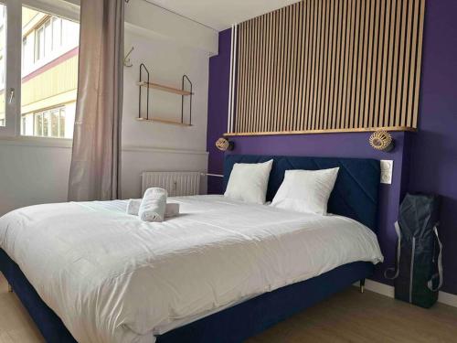 um quarto com uma cama grande e paredes roxas em Le club green - appt 45 m2 - 4P - parking em Metz