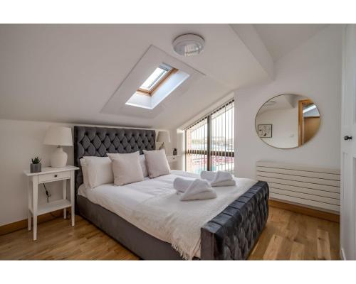 - une chambre avec un grand lit et un miroir dans l'établissement Central Belfast Apartments Pottinger's Quay, à Belfast