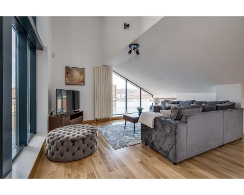 a living room with a couch and a television at Central Belfast Apartments Pottinger's Quay in Belfast