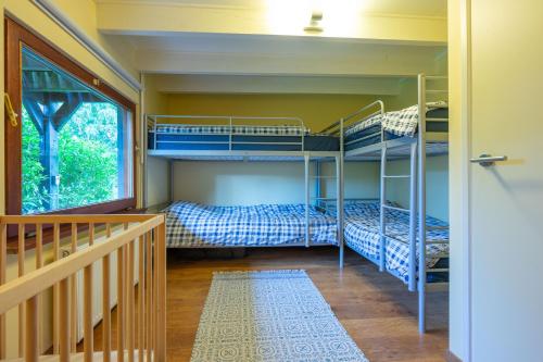 a room with two bunk beds and a staircase at Au Ptit Bois Charmant in La Roche-en-Ardenne