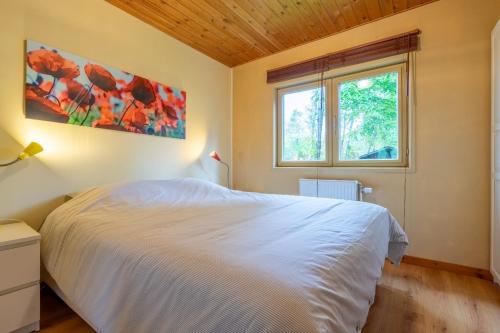 una camera con un letto bianco e una finestra di Au Ptit Bois Charmant a La-Roche-en-Ardenne