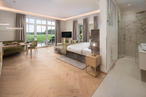 a bedroom with a bed and a desk and a bathroom at SCHLOSSRESIDENZ - Boutique Apartments & Hotel Suiten in Schloß Ricklingen