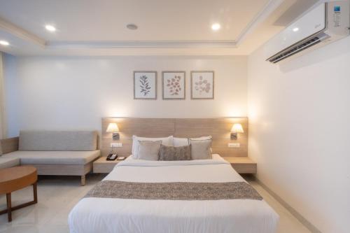 a bedroom with a large bed and a couch at Terrakotta Rishikesh in Rishīkesh