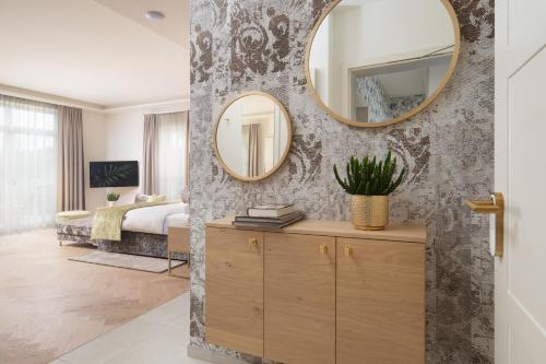 a bedroom with a bed and a mirror on a wall at SCHLOSSRESIDENZ - Boutique Apartments & Hotel Suiten in Schloß Ricklingen