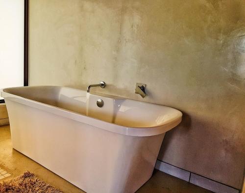a white bath tub sitting in a room at Selwane Nature Reserve in Gravelotte
