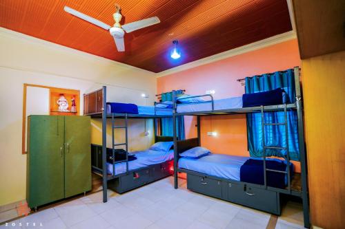 two bunk beds in a room with a ceiling fan at Zostel Mysore in Mysore