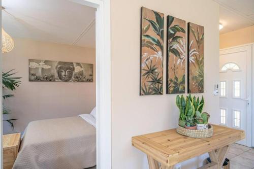 a bedroom with a bed and a table with plants at Gaia Residences with lush garden and pool in Argostoli