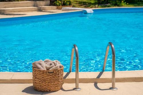 a basket of towels next to a swimming pool at Gaia Residences with lush garden and pool in Argostoli