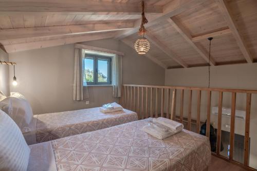a bedroom with two beds and a window at Alexandras's Mansion - Fragkia's House in Ayiá