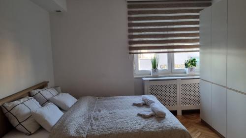 a bedroom with a bed with a stuffed animal on it at Apartman Lumi in Čakovec