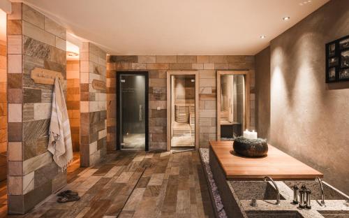 łazienka z drewnianym stołem i płytkami na ścianie w obiekcie Falkensteiner Hotel & Spa Sonnenparadies w mieście Terento