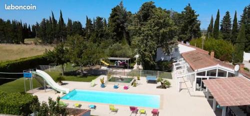 - une vue sur la piscine et une maison dans l'établissement Villa spacieuse et élégante à Meynes avec piscine privée, à Meynes