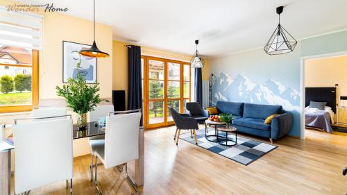 un salon avec un canapé bleu et une table dans l'établissement Wonder Home - Domek Karkonosz z kominkiem i dwoma sypialniami - tuż przy stoku Myśliwska 42-1, à Karpacz