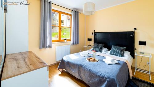 une chambre avec un grand lit avec une couverture bleue dans l'établissement Wonder Home - Domek Karkonosz z kominkiem i dwoma sypialniami - tuż przy stoku Myśliwska 42-1, à Karpacz
