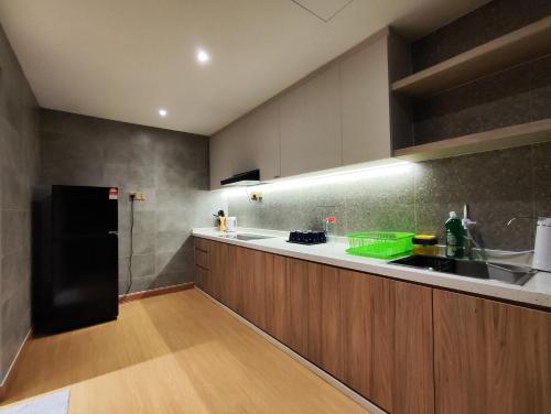 cocina con nevera negra y armarios de madera en Fahrenheit 88 Pavilion Newly Renovated By Abby Stay en Kuala Lumpur