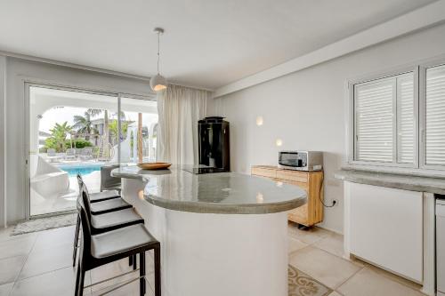 a kitchen with a counter with stools at VILLA8 in Puerto de Santiago