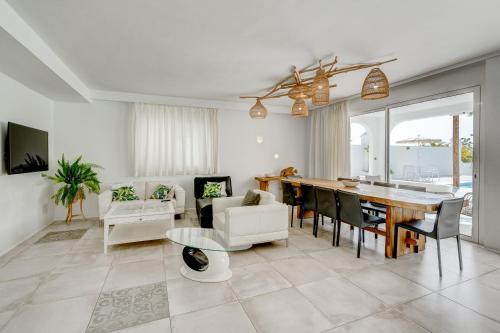 uma sala de jantar e sala de estar com mesa e cadeiras em VILLA8 em Puerto de Santiago