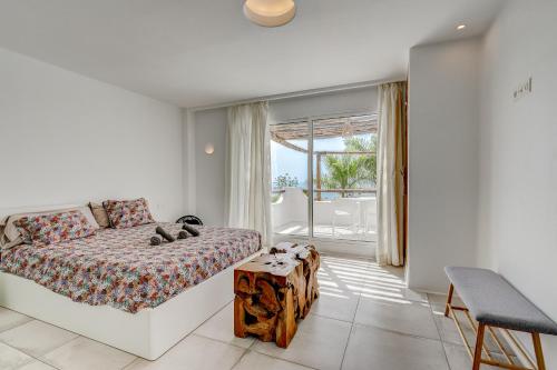 a bedroom with a bed and a table and a window at VILLA8 in Puerto de Santiago