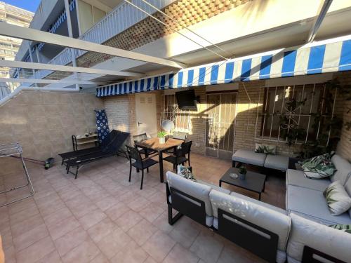 un patio con sofá, mesa y sillas en Apartamento con terraza en San Juan Playa, en Alicante