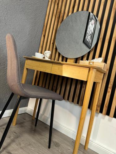 a desk with a chair and a mirror on it at Svatého Pasáž BOUTIQUE Apartments with free parking in Trnava