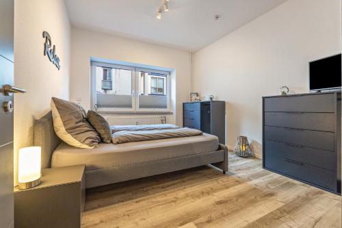 ein Schlafzimmer mit einem Bett, einem Fenster und einer Kommode in der Unterkunft Sanierter Wohntraum in Linden in Hannover