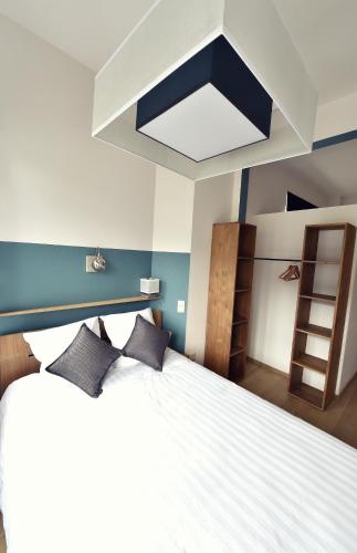 a bedroom with a large white bed with two pillows at Côté Sax bed and breakfast in Dinant
