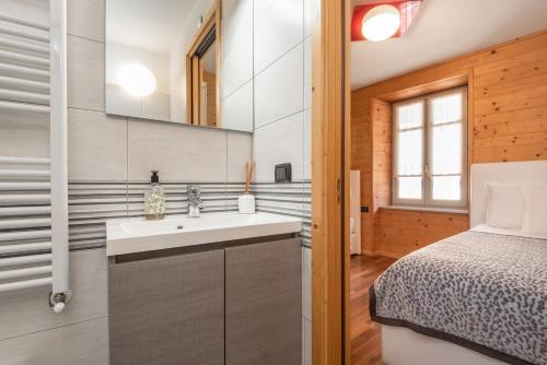 a bathroom with a sink and a bed in a room at Locanda dei cantù in Carona