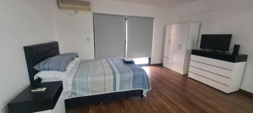 um quarto com uma cama e uma televisão de ecrã plano em Monoambiente Grande Pedraza2134 em Buenos Aires