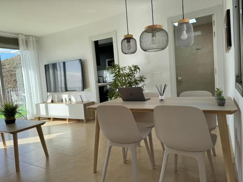 uma sala de jantar com uma mesa com um computador portátil em Apartamento Cervantes con terraza y vistas al mar em Carboneras