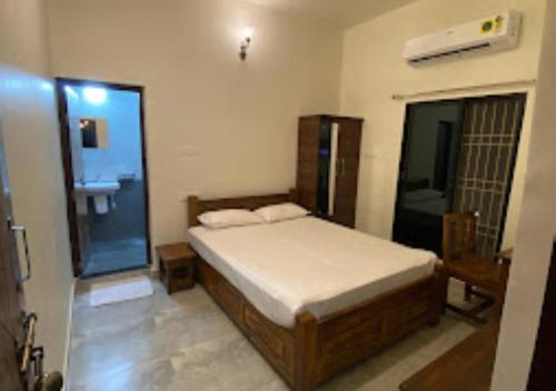 a bedroom with a bed and a bathroom with a sink at Erisha Tadoba Chandrapur in Mohurli