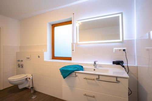 uma casa de banho com um lavatório, um WC e uma janela. em Ferienwohnung Bodensee Gaienhofen em Gaienhofen